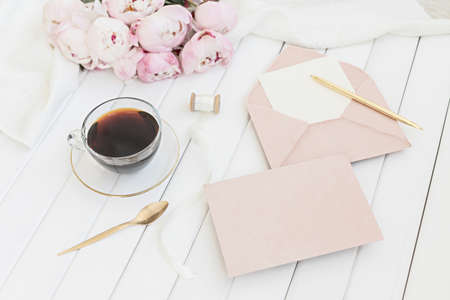 Wedding greeting card concept. Top view mockup on wooden background with peonies flowers. Flat lay...