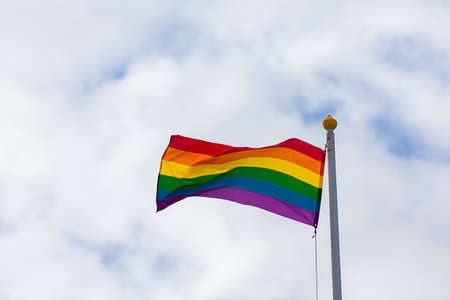 Flag with a rainbow on a blue sky background. lgbt concept.の写真素材