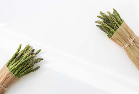 Raw stems asparagus tied with twine. Vegetable food isolated on white background.の写真素材