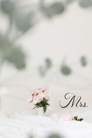 Bouquet of pink peonies on white bed linen. Modern interior in the bedroom. Wedding and festive style.の写真素材