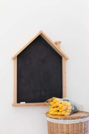 Back to school.Yellow tulips on black board background.の写真素材