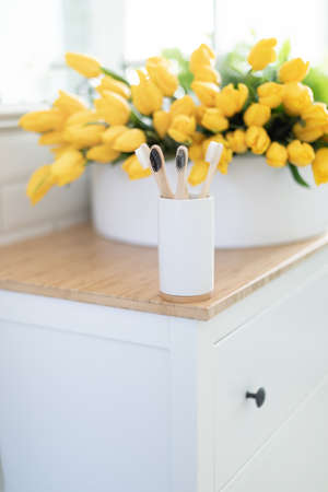 Zero waste concept. A bouquet of peonies in the bathroom. Bamboo toothbrush.の写真素材
