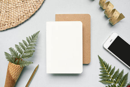 Tropical workspace concept. Notepad and tropical palm leaves. Mockup presentation workplace.の写真素材