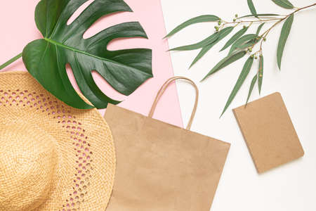 Flat Lay shopping concept with paper bag and tropical leaves. Elegant composition with elegant accessories.の写真素材