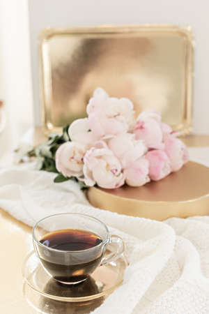 Styled composition with pink tulips on gold background. Floral frame and white textile. Border top view.の写真素材