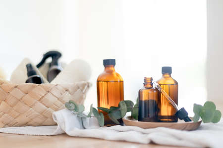 Essential oils in glass dark bottle. Skin and body care treatment concept. Eucalyptus branch.の写真素材