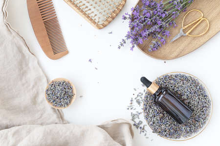 Amber bottle of lavender essential oil. Flat lay concept skin care. Light background with lavend flower.の写真素材