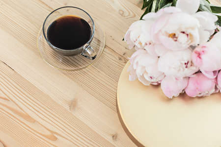 Styled composition with pink tulips and cup coffee on gold background. Flat lay floral frame and...