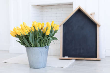 Back to school.Yellow tulips on black board background.の写真素材