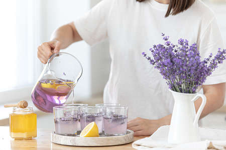 A young girl makes lemonade from lemons and lavender. Woman making a summer drink.の写真素材