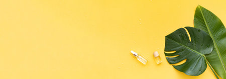 Essential oils bottles and banana leaf on a tropical background. Skin and body care concept.の写真素材