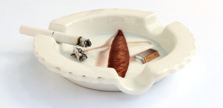 Smoking cigarette put on ashtray. Isolated on white background.の写真素材