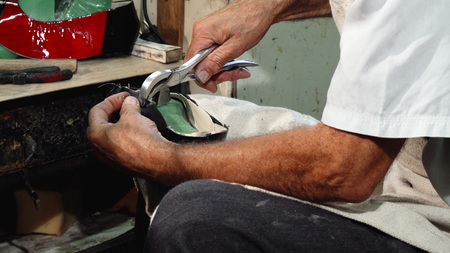 Cropped shot of a senior shoemaker working at his custom footwear shop, making new shoes. Craftsman...