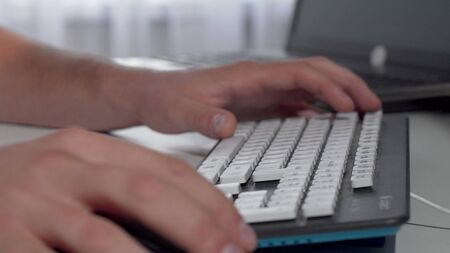 Male hands typing on computer keyboard. Cropped shot of a nab working on computer, typing and...