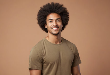 A man with afro hair wearing an olive tee smiling casually at the camera.の素材