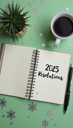 An open notebook with 2025 Resolutions written in bold letters sits on a vibrant green background, accompanied by a cup of coffee and a small potted plant. This inviting scene captures the essence of fresh beginnings and personal growth, perfect for inspiring motivation and reflection as the new year approaches.の素材