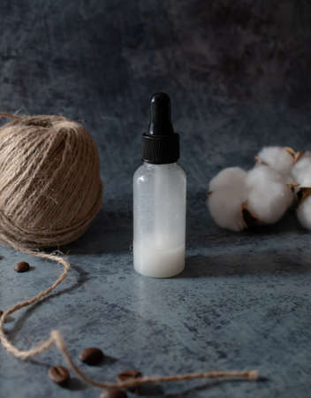 white serum bottle on dark background. homemade skincare product. organic zero waste cosmetics. selective focusの写真素材