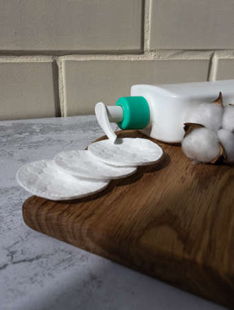 white bottle with organic cosmetics product for beauty morning routine with cotton bolls and...