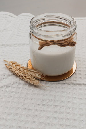 Glass jar with vegan milk, wheat. ingredients for making alternative dairy products. self care concept. healthy eating. no allergy, lactose free. close up, selective focusの写真素材