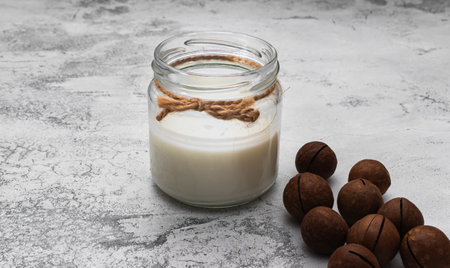World Vegan Day concept. Nut milk in glass jar with macadamia. Homemade alternative dairy product....