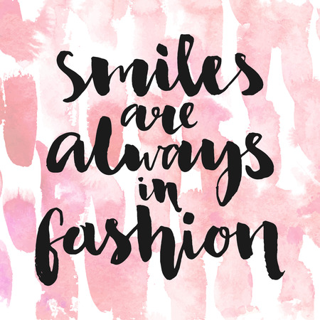 Smiles are always in fashion. Inspirational quote handwritten with black ink and brush, custom lettering for posters, t-shirts and cards. Vector calligraphy on pink watercolor strokes background.のイラスト素材