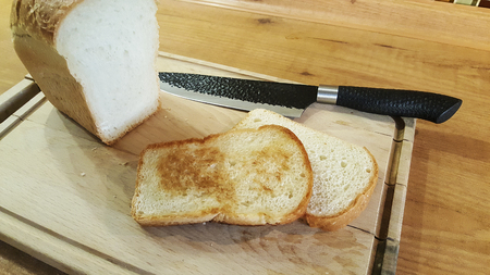 a slice of bread roasted in a pan on an old wooden boardの写真素材