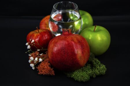 art photo glass of water red and green apples moss of different colors on a black background 2の写真素材