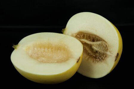 art photo ripe melon cutting in half with seeds on a black backgroundの写真素材