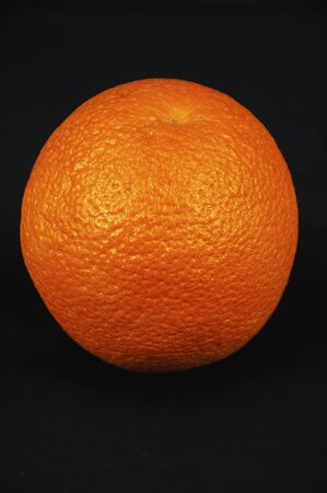 art photo of a whole orange closeup on a black backgroundの写真素材