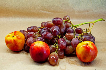 bunch of grapes with nectarine close-up on a beige backgroundの写真素材