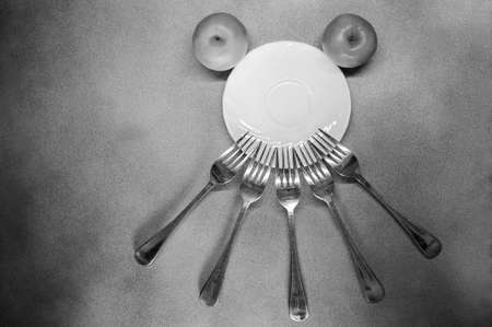 horizontal photo of a fork and around a plate like a face close-up with apples on a gray backgroundの写真素材