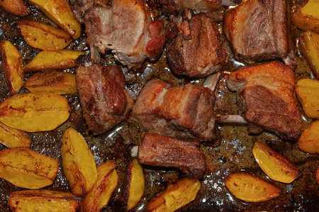 baked pork ribs and potatoes in oil and paprikaの写真素材