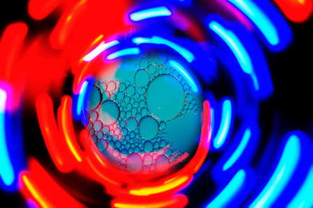 art photo of an abstract background of radial blue red and yellow stripes of light on a black backgroundの写真素材
