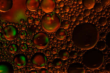 Artistic photo of oil drops close up in red tones for backgroundの写真素材