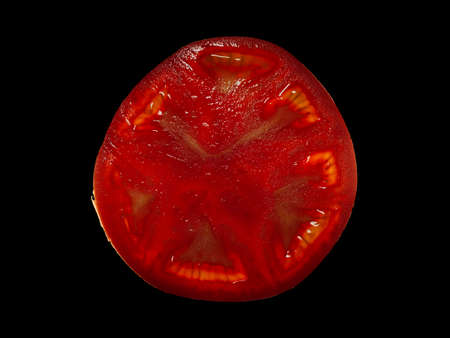 art photo of ripe red tomato isolated on black backgroundの写真素材