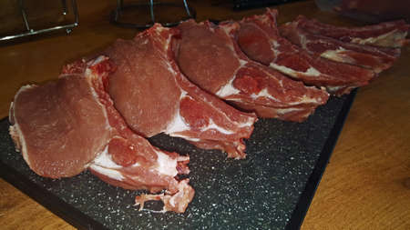 photo of pork tenderloin on a rib cut into pieces on a board on a wooden tableの写真素材