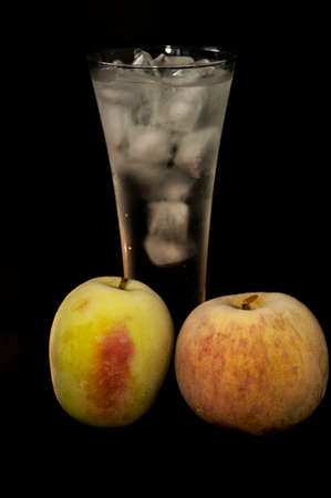 frozen apples and glasses with ice on a black backgroundの写真素材