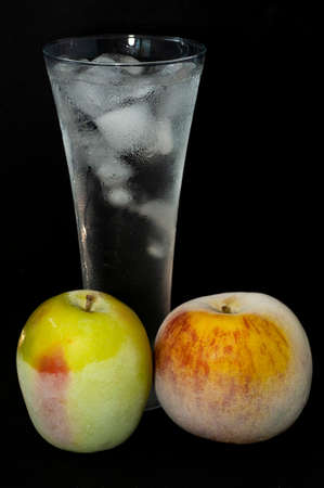 frozen apples and glasses with ice on a black background