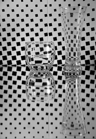 glasses with water and reflections on black and white checkered backgroundの写真素材