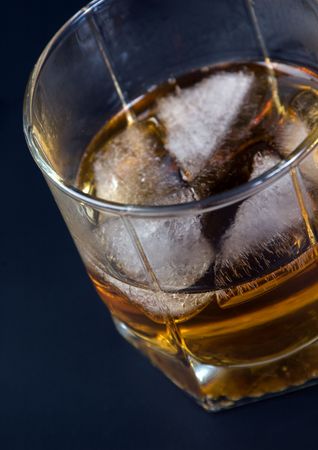 Whisky in a glass with ice against a dark backgroundの写真素材