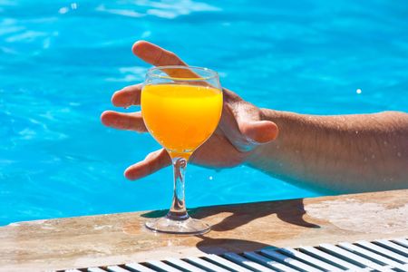 The man's hand reaches for a glass with orange juice
