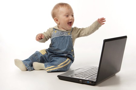 The small smiling happy kid with the laptop on the white background, isolated.の写真素材