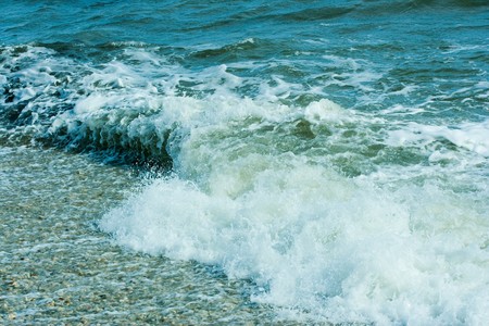 The twirled sea wave approaching on coastの写真素材