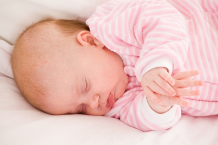 sleeping baby in striped toddlers close upの写真素材