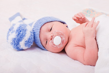 newborn baby (at the age of 7 days) sleeps in a knitted striped hat