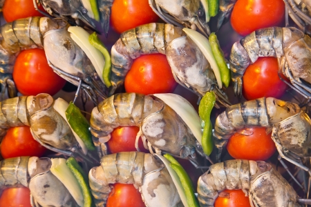 Rows of grilled big shrimps with tomatoes on the counter in buffetの写真素材
