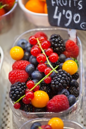 Container with different fresh berries with price on counterの写真素材