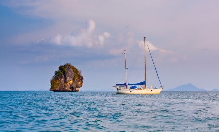 Boat on the sea with a rock islandの写真素材