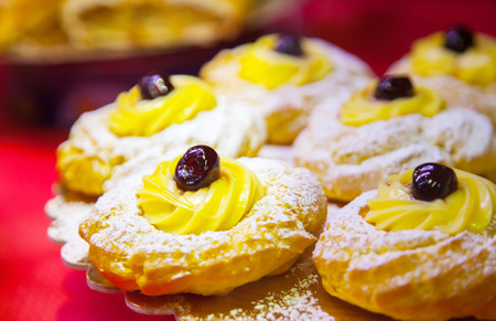 Tasty cakes in whipped cream on a counter of shopの写真素材