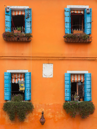 Venice, Burano: the small yard with bright walls of housesの写真素材